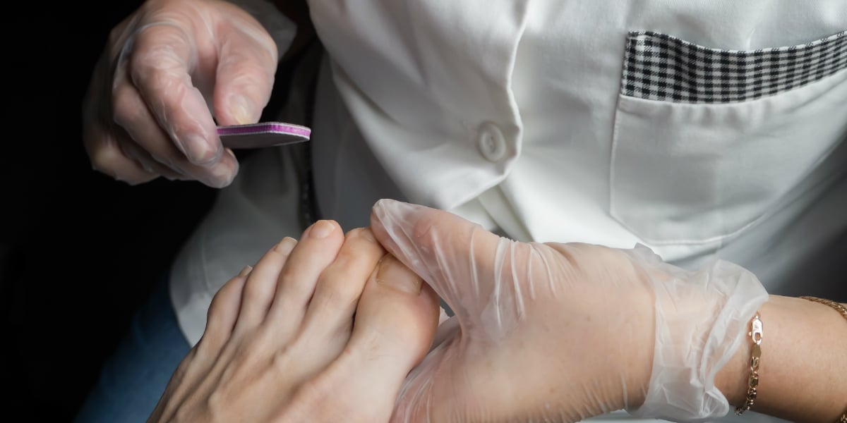Foot Care nail specialist filing toenail